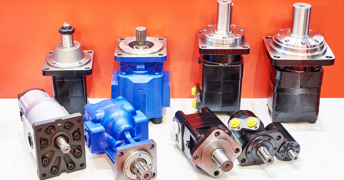 Several industrial hydraulic motors and hydraulic pumps of different sizes grouped together on a plain white surface.