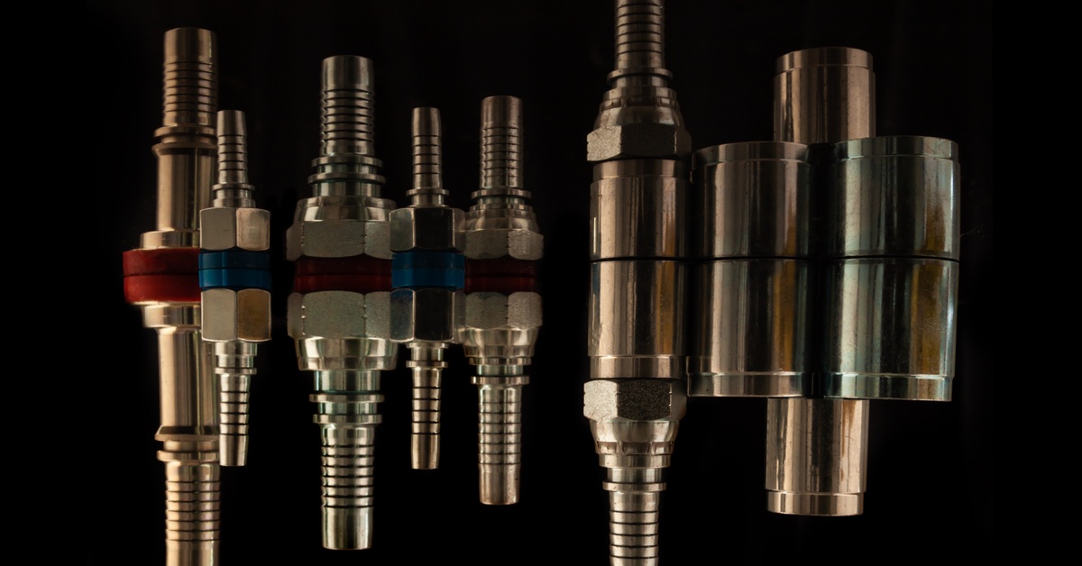 Several hydraulic hose ends and fittings grouped together. Their reflections are shown underneath them on a black background.