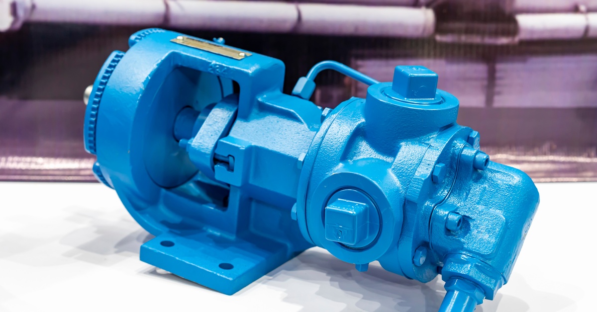 A close-up of a blue metal rotary gear pump for pumping water or liquid in an industrial setting on a table.