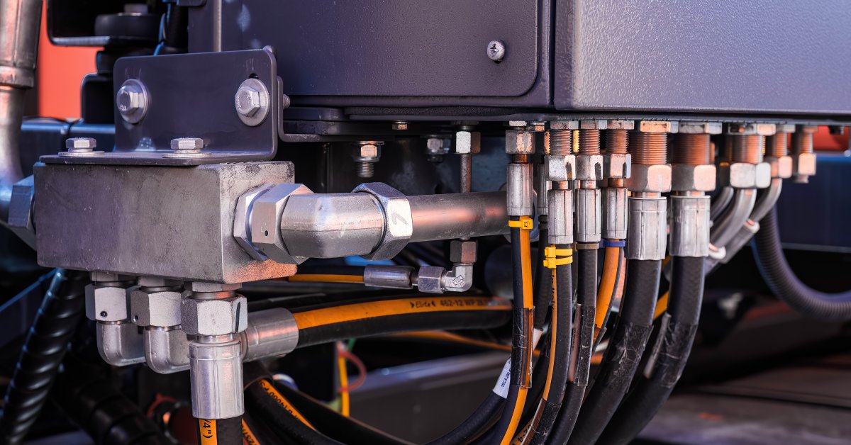 A close-up of a hydraulic system with different components. Hoses of many sizes and various fittings are attached to the system.