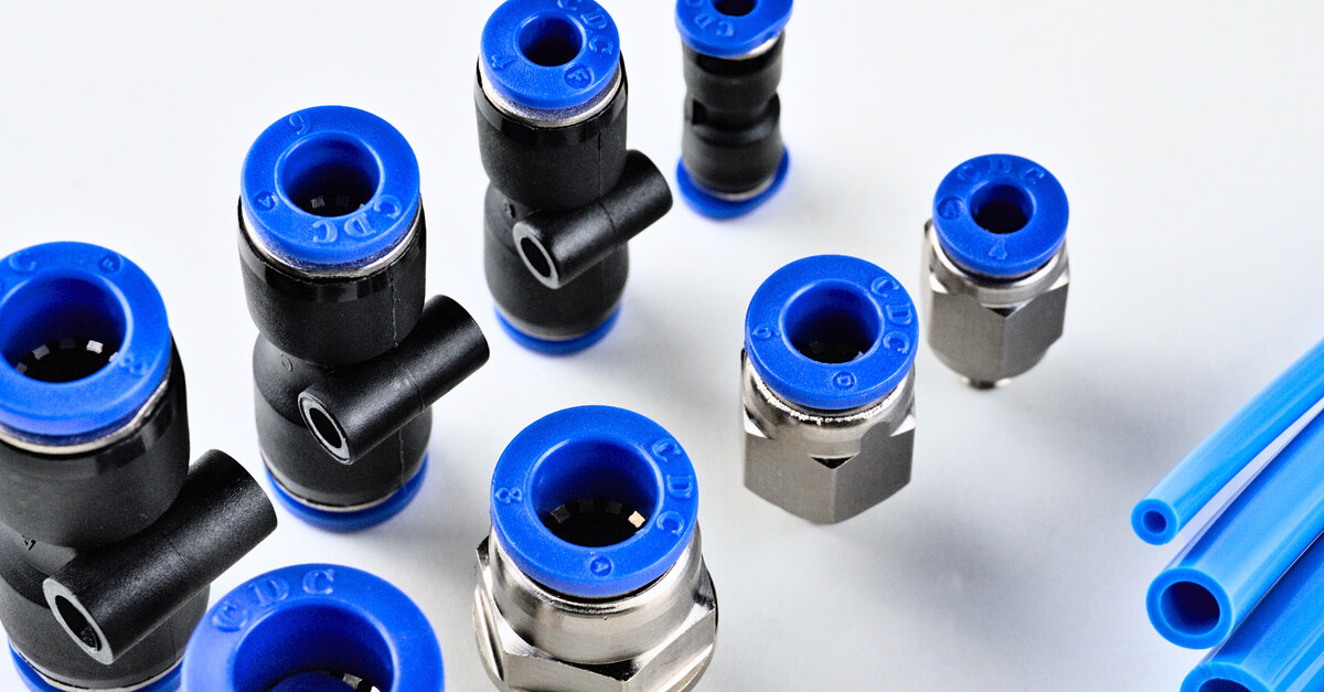 Several brass and plastic pneumatic fittings of various sizes. Each fitting contains blue-colored parts.