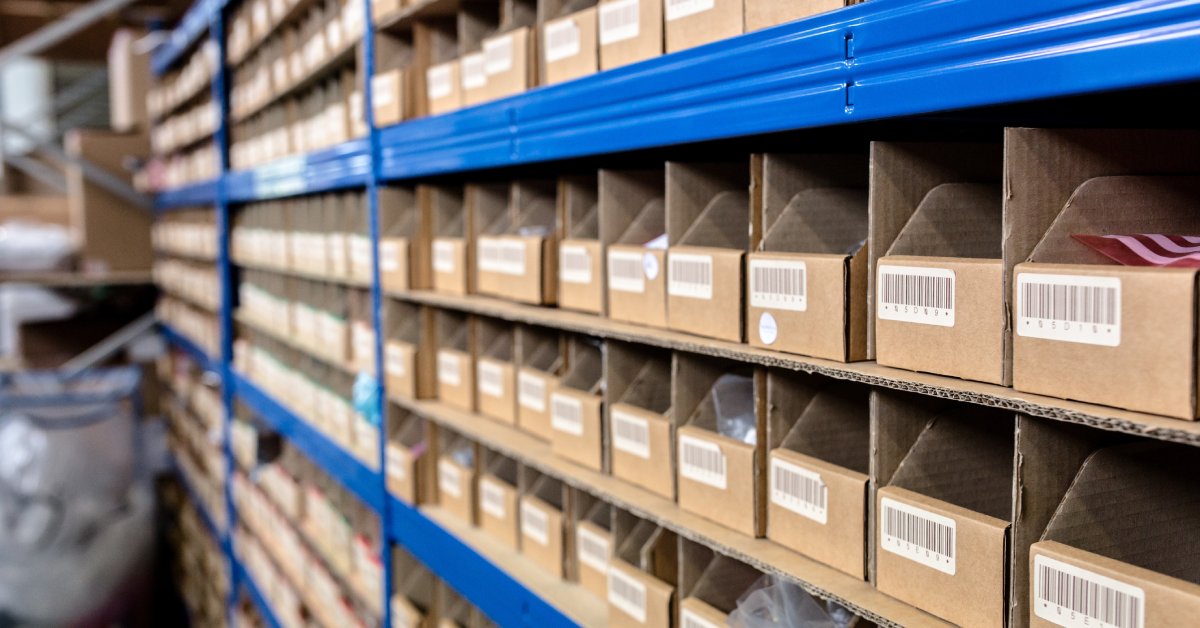 A pigeonhole system comprised of brown cardboard containers for storing manufactured items in a warehouse.