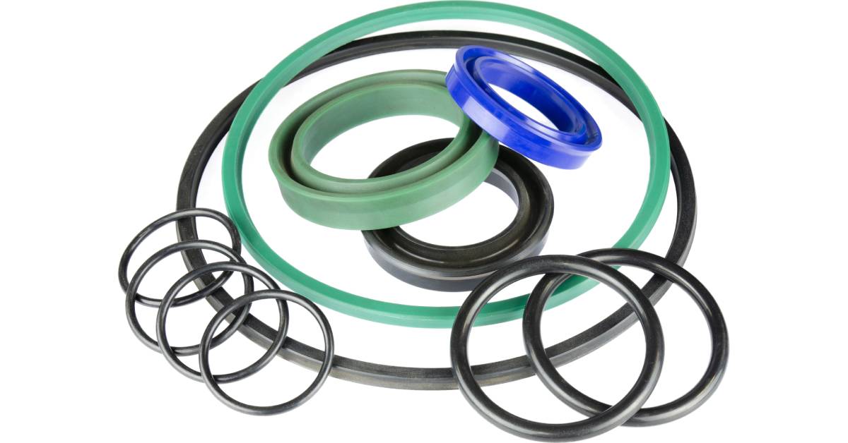 An assortment of hydraulic seals of different colors and sizes grouped together against a plain white background.